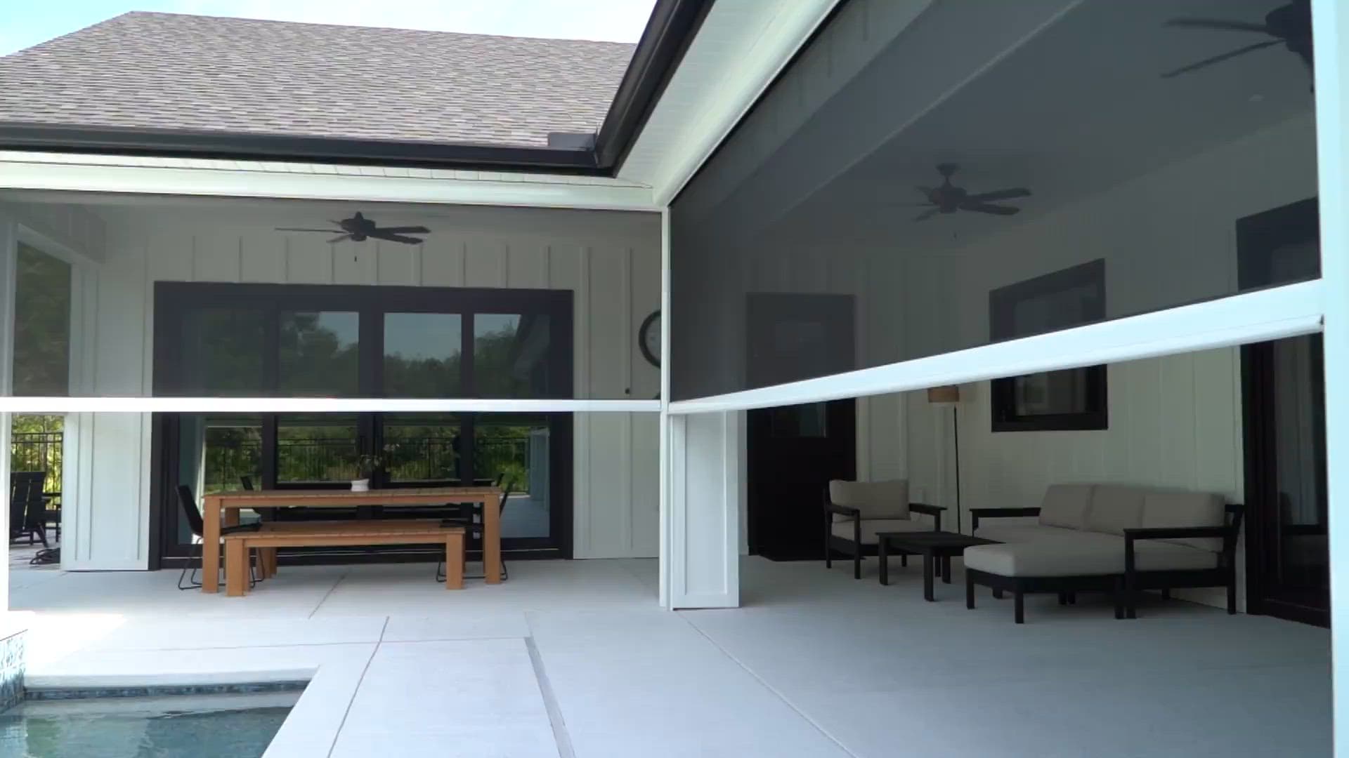 Motorized patio screens protecting an outdoor living space